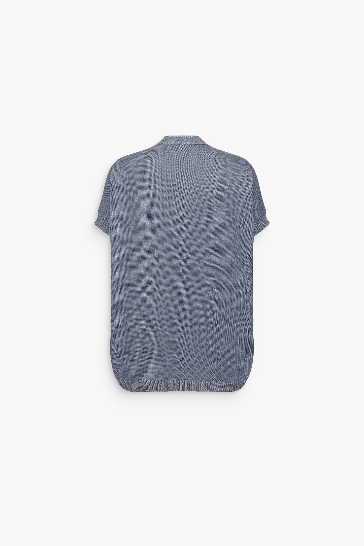 Détail d’un top bleu denim sans manches, souligné par une maille légère et une broderie délicate.