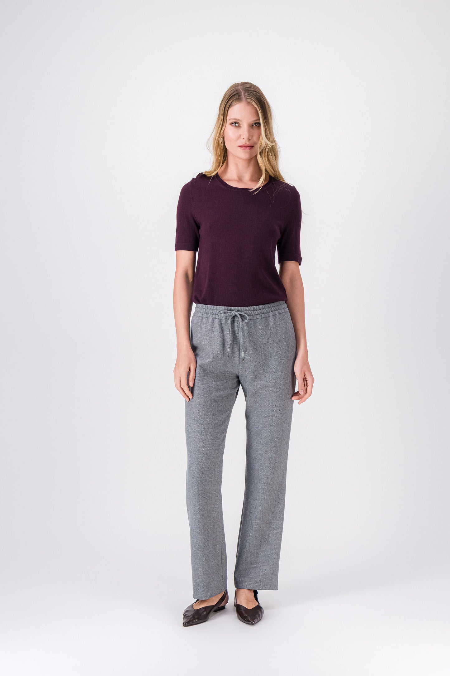 Pantalon droit gris moyen, coupe fluide et taille ajustable avec finitions métalliques discrètes.