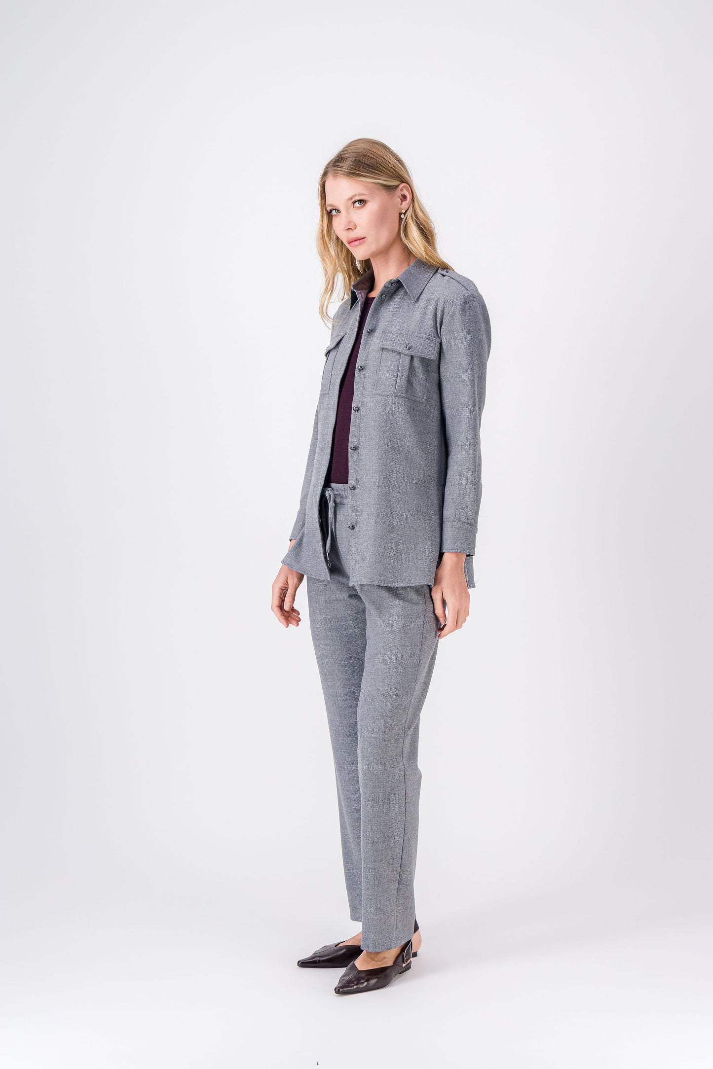 Chemise gris moyen, style moderne et subtil avec boutons argentés et détails aux épaules.