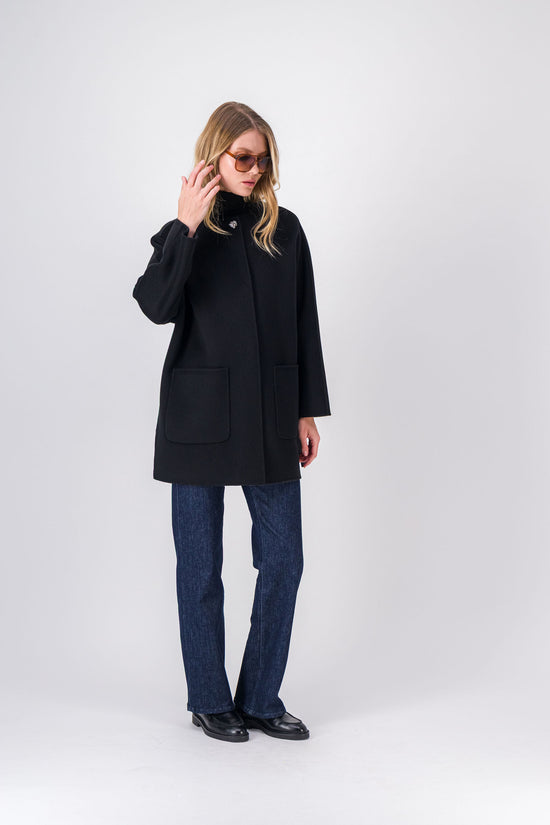 Manteau noir mi-long, coupe droite avec manches longues et boutons bijoux raffinés.