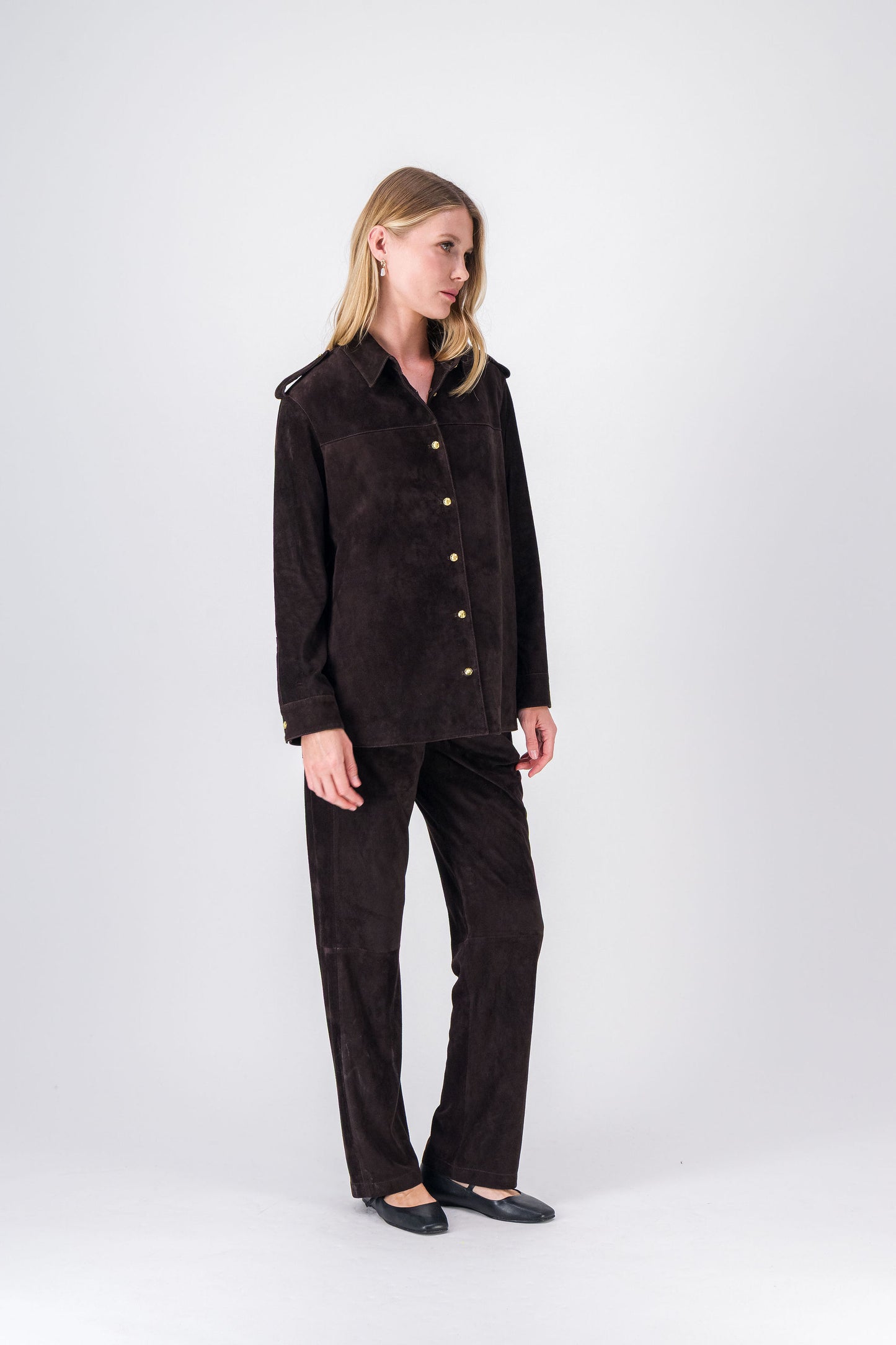 Vue du blouson en daim ébène, silhouette droite et détails raffinés.