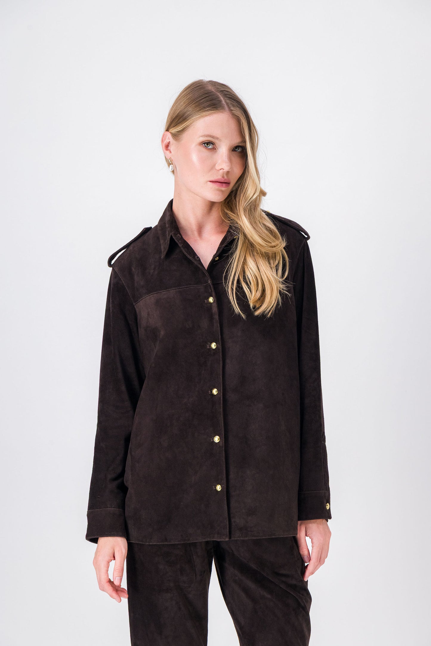 Blouson en daim ébène, coupe droite avec col classique et détails dorés.