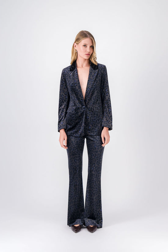 Pantalon long en velours ébène à imprimé léopard, coupe évasée et texture raffinée.