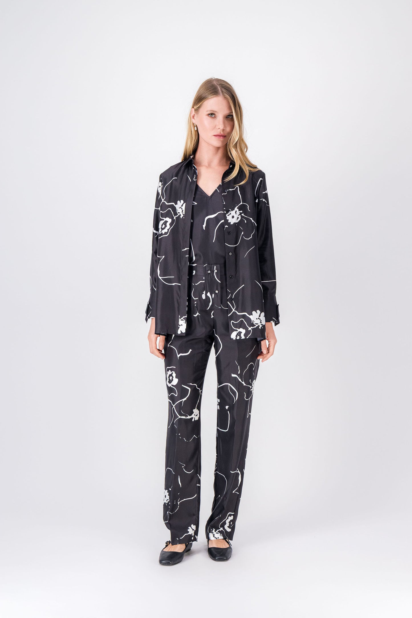 Une chemise noire en soie, aux motifs floraux subtils et aux finitions soignées, pour un style chic et naturel.