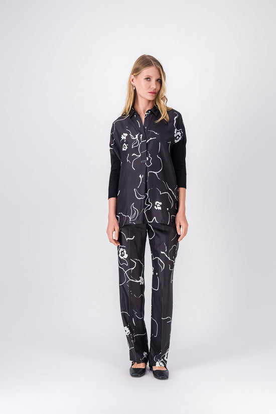 Tunique noire à imprimé floral délicat, coupe ample avec col en V et manches en jersey.