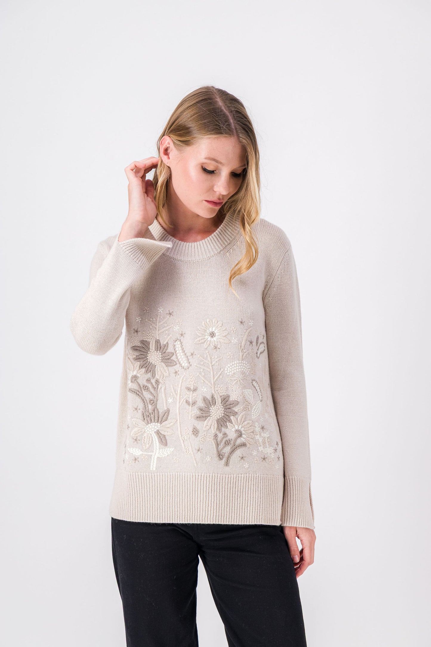 Un pull droit en laine et cachemire, à l’allure sobre, souligné de broderies florales et d’une teinte minérale qui traverse les saisons avec justesse.