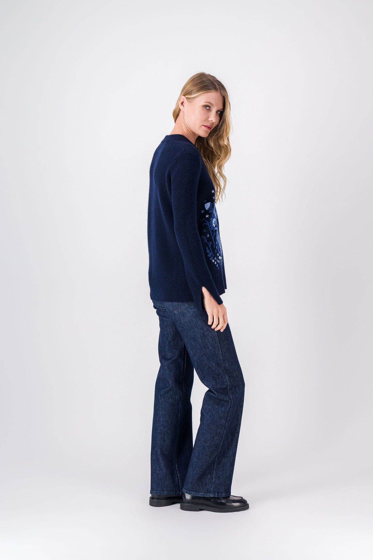 Pull bleu marine, style élégant et structuré avec détails floraux délicats.