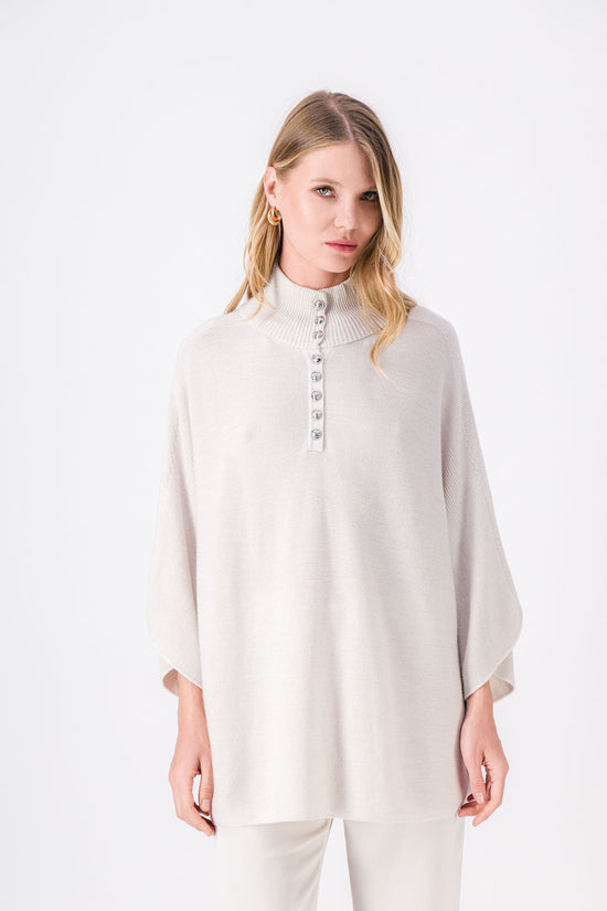 Pull en pure laine, col roulé, coupe droite et boutons métallisés. 