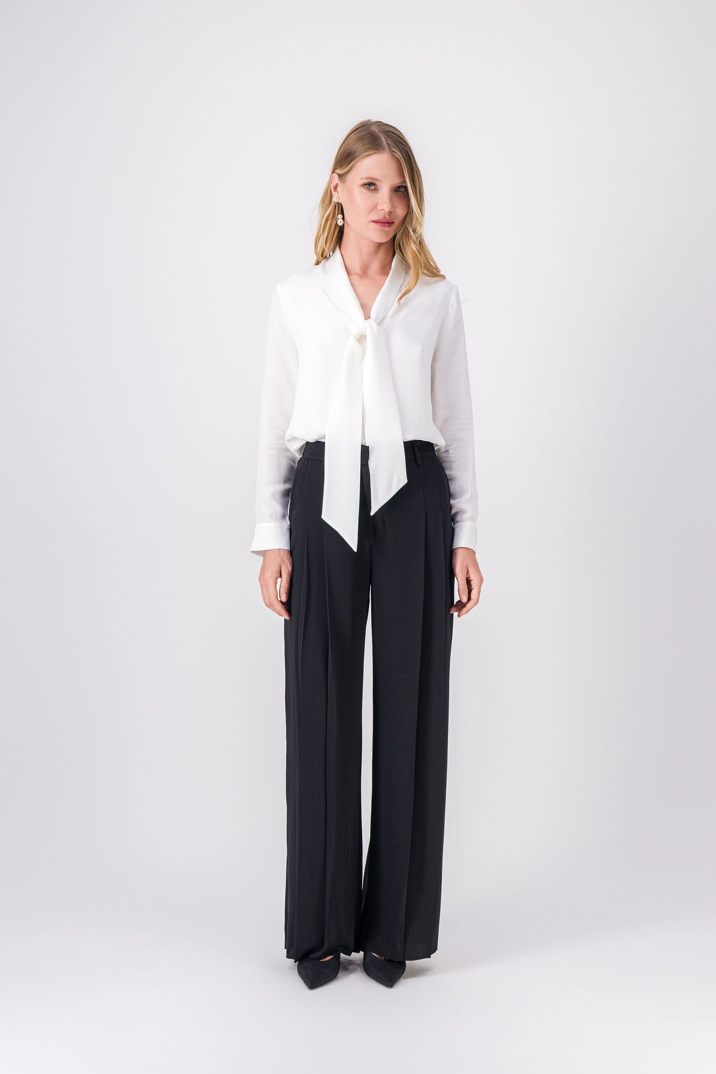 Chemise blanc cassé en soie, col lavallière noué et patte de boutonnage dissimulée.