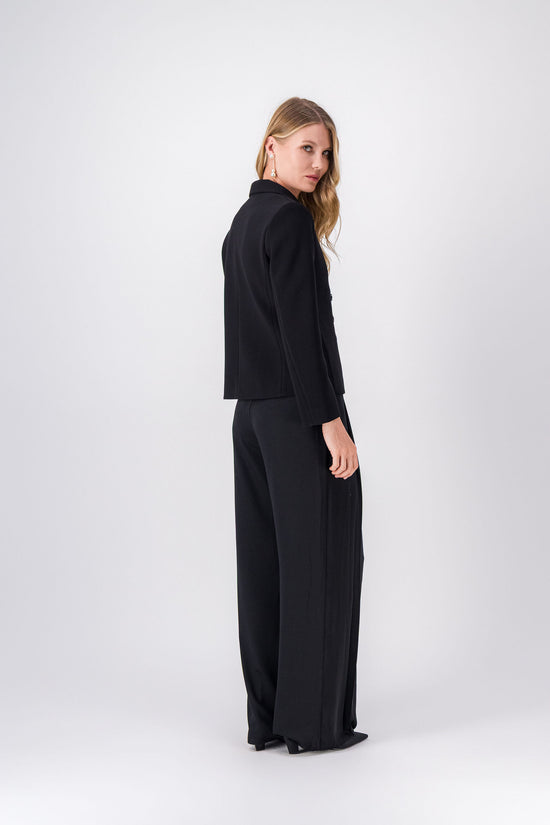 Pantalon fluide noir, style élégant et moderne avec détails subtils et soignés.