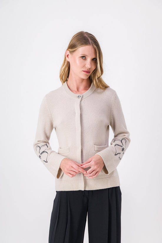 Un cardigan tout en nuances, où la teinte minérale s’allie à la finesse des broderies florales