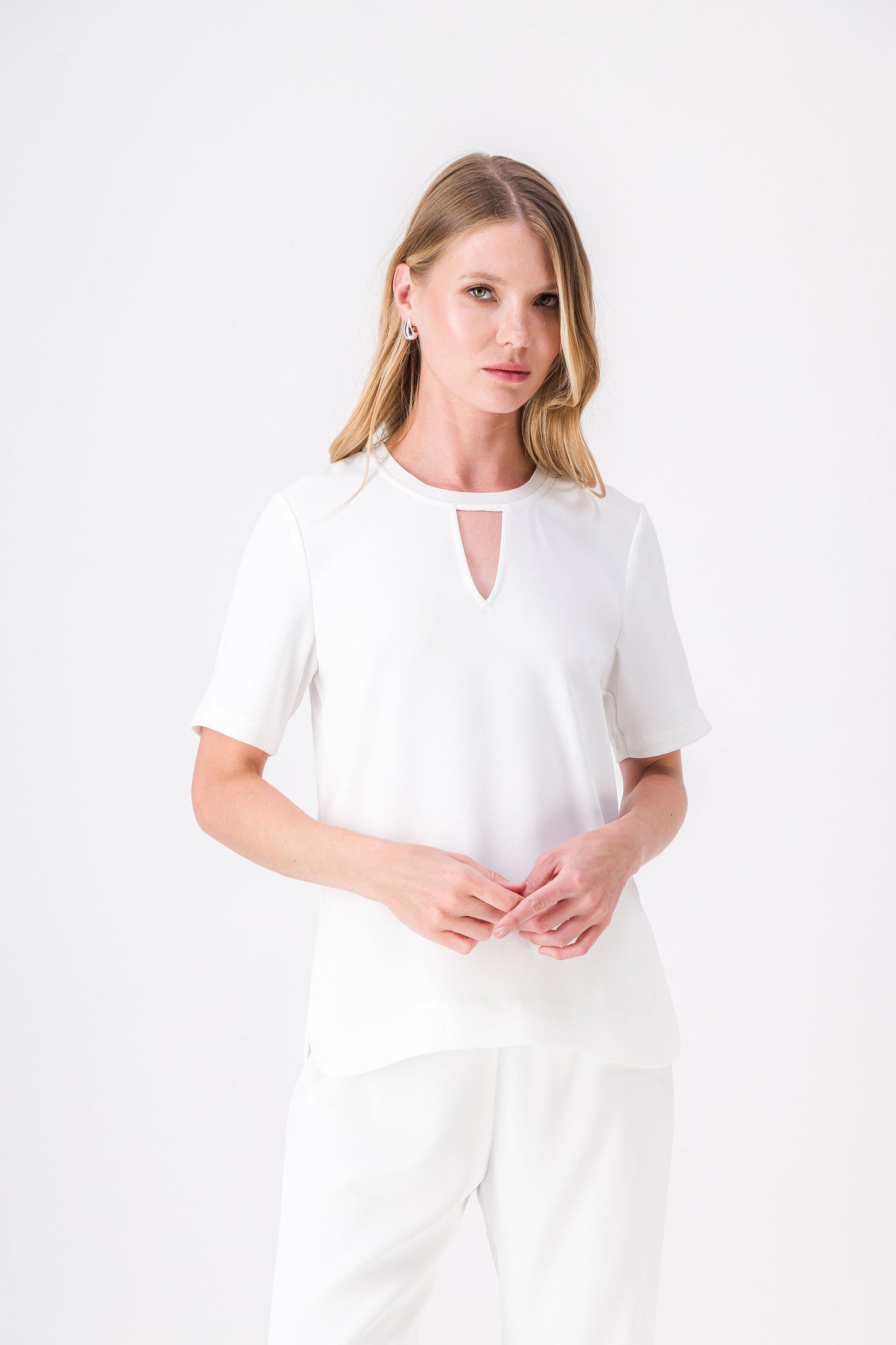 Top blanc cassé, style simple et moderne, détails raffinés et fentes sur les côtés.
