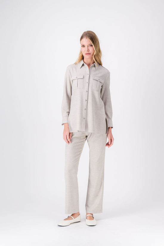 Chemise couleur béton, coupe droite avec pattes aux épaules et boutons argentés.