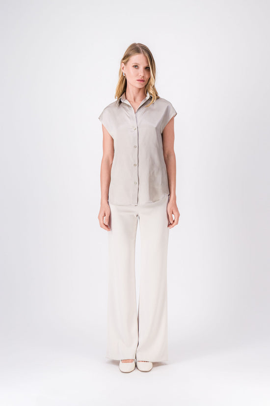 Tunique sans manches en soie ton béton, coupe droite avec col classique et patte de boutonnage apparente.