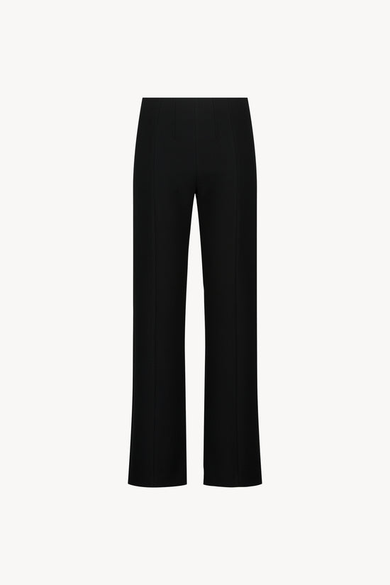 Pantalon ajusté noir avec taille élastique et fentes italiennes, alliant confort et élégance intemporelle.