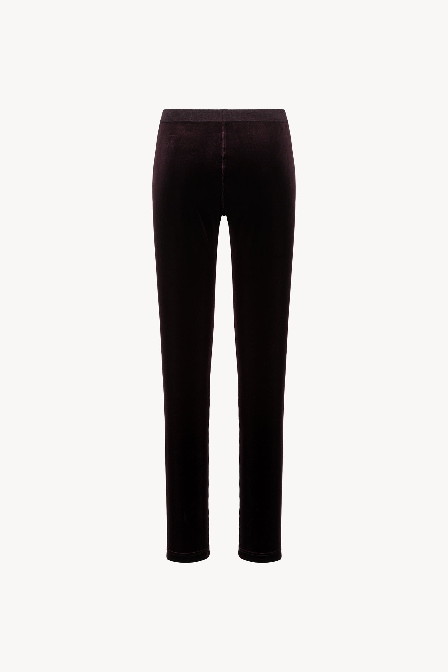 Coupe ajustée en velours grenat. Taille élastique, zip latéral discret.