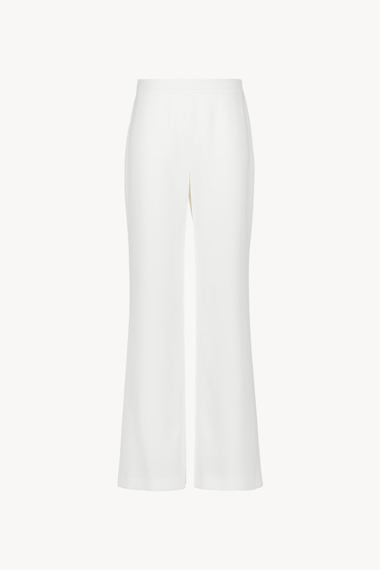 Pantalon taille haute à coupe évasée. Fermeture zippée invisible. Tissu fluide au tomber net.