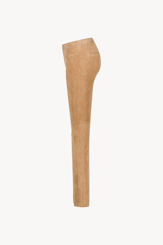 Pantalon en daim beige ajusté avec poches décoratives et taille élastique. 