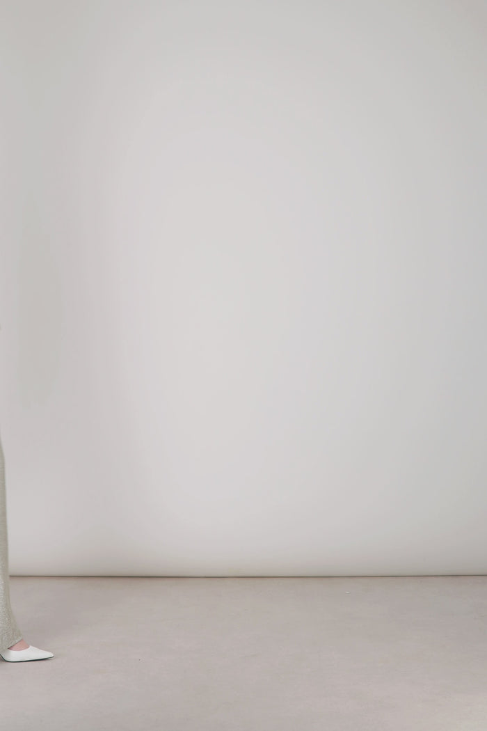 Texture lumineuse du jersey lamé argent captant la lumière.