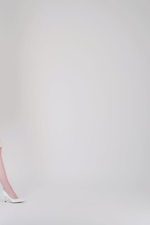 Jupe crayon doublée en tweed jaune clair à coupe structurée.