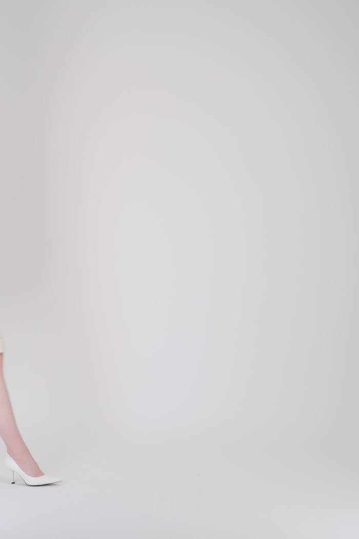 Jupe crayon doublée en tweed jaune clair à coupe structurée.