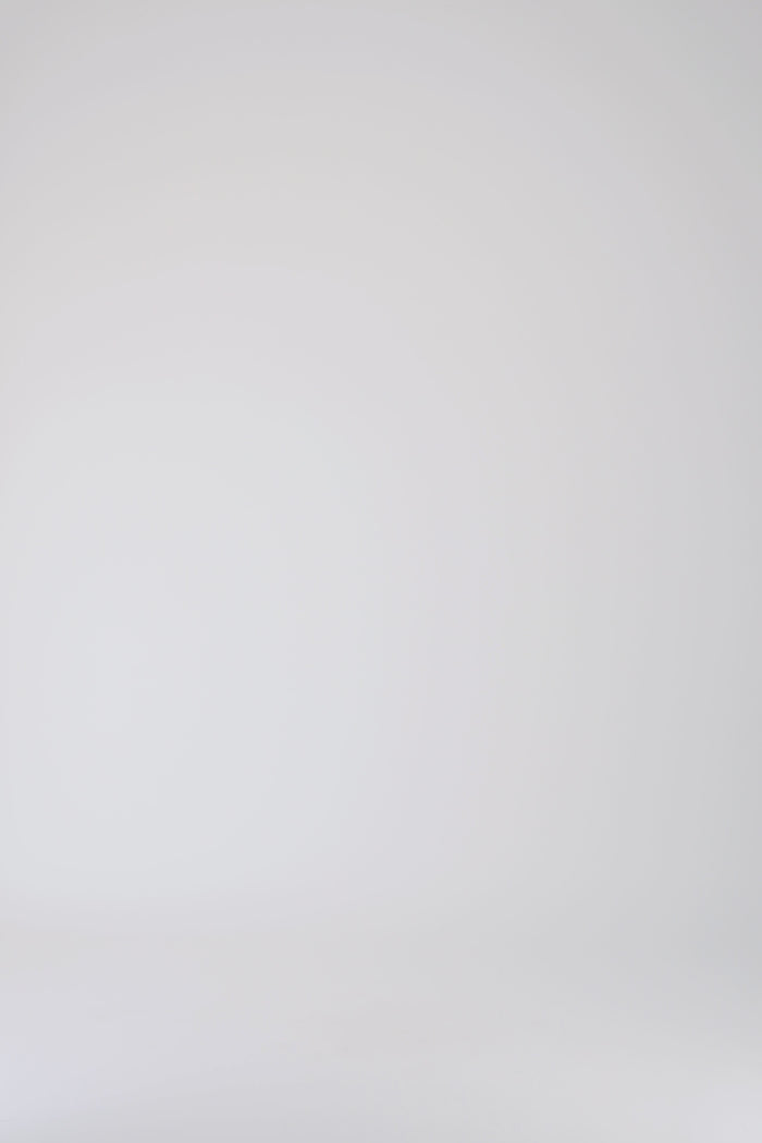 Détail du cordon de serrage sur pantalon droit blanc cassé à taille élastiquée.