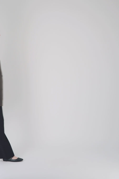 Veste droite en cuir marron avec poches discrètes et finitions surpiquées.