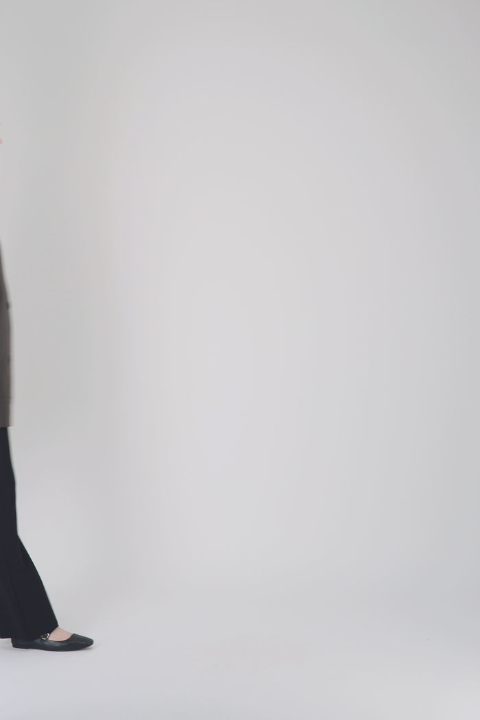 Veste droite en cuir marron avec poches discrètes et finitions surpiquées.