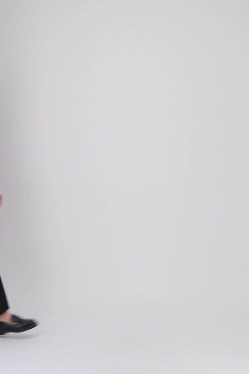 Un jean noir droit, élégant et fonctionnel, avec rivets métalliques et finitions soignées pour un style raffiné.