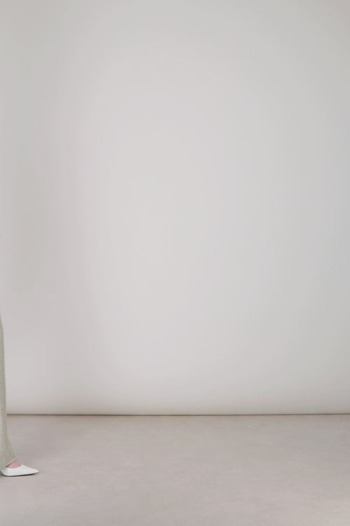 Ouverture discrète sur le côté du bas de jambe sur pantalon en jersey lamé argent.