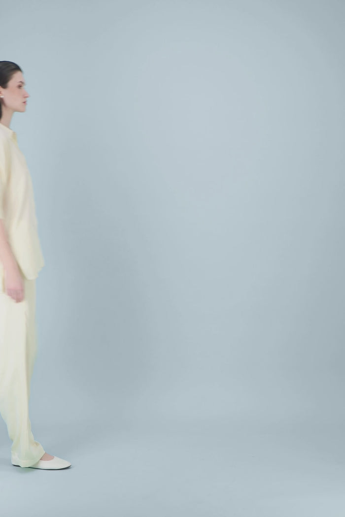 Chemise tunique en soie mélangée jaune clair avec patte de boutonnage cachée et coupe ample.