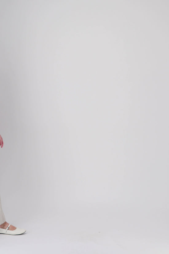 Cette robe courte en teinte beton joue sur les lignes classiques du col chemise et de la patte de boutonnage.