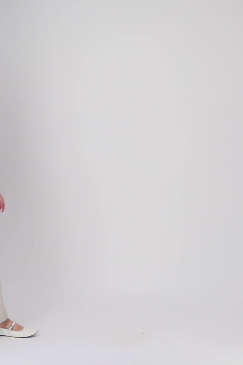 Cette robe courte en teinte beton joue sur les lignes classiques du col chemise et de la patte de boutonnage.