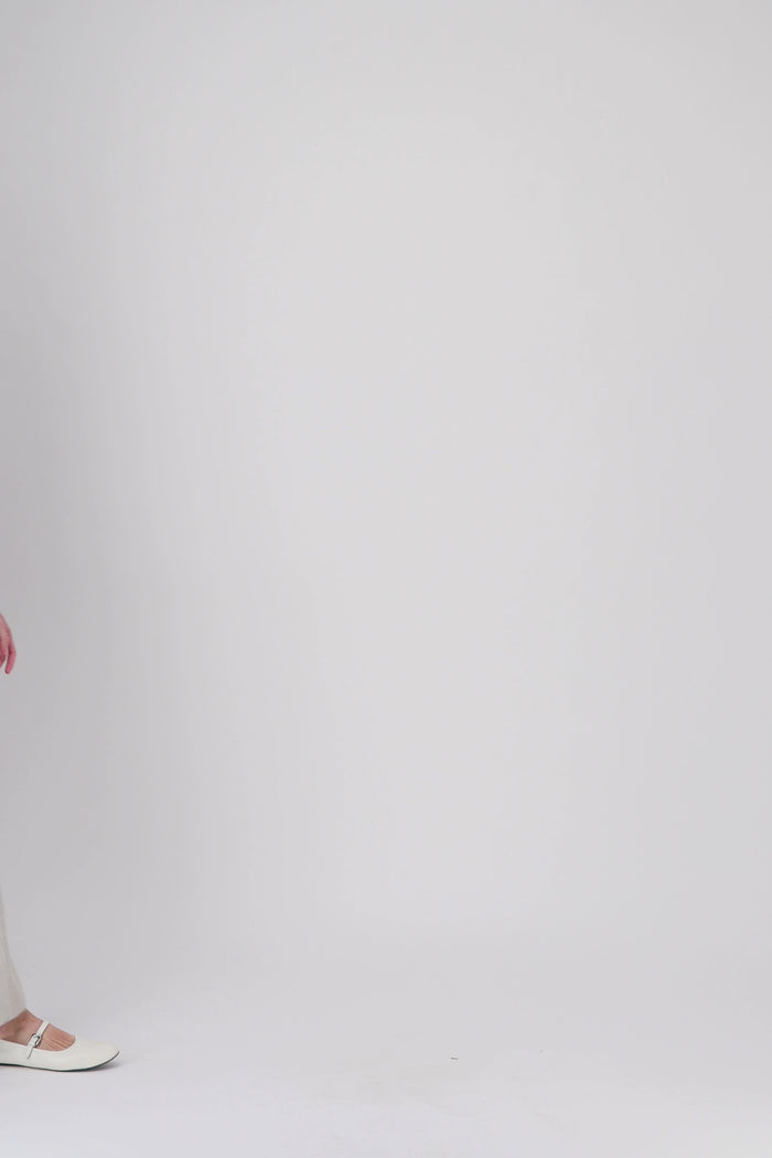 Cette robe courte en teinte beton joue sur les lignes classiques du col chemise et de la patte de boutonnage.