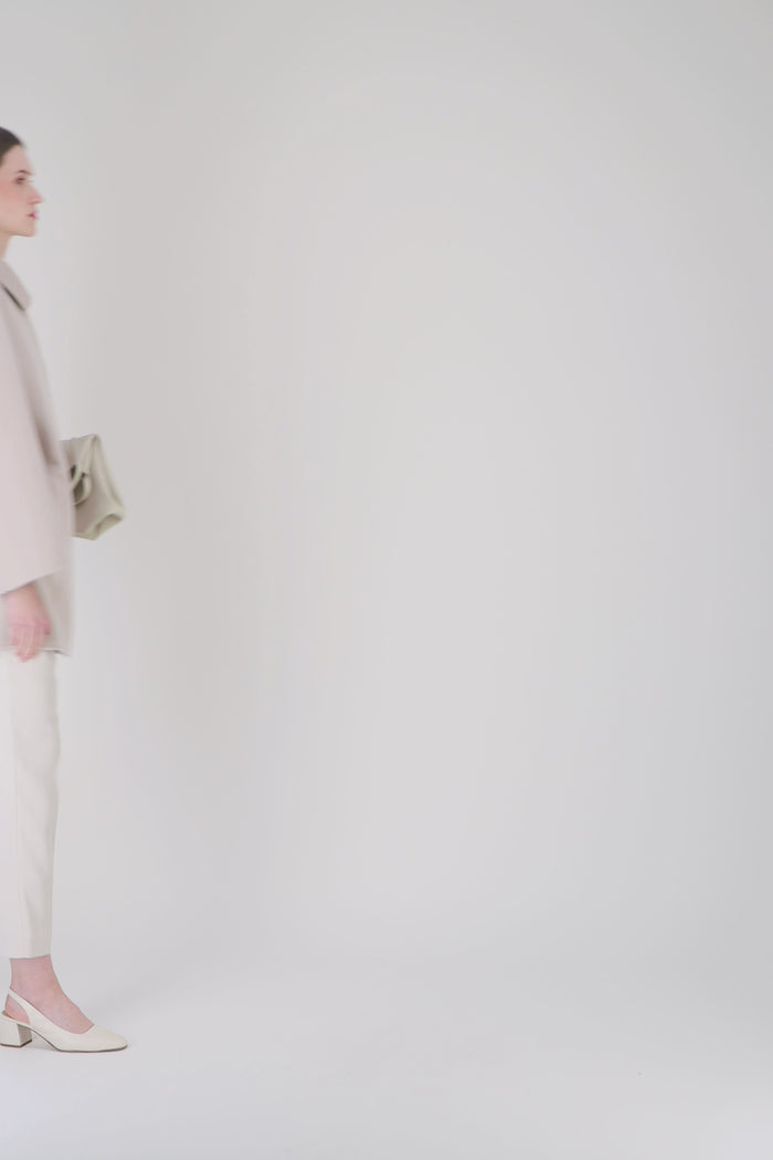 Détail du lien de serrage intégré à la ceinture sur pantalon droit fuselé beige.