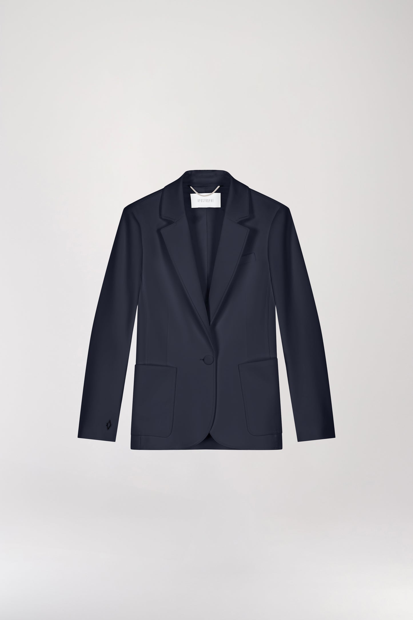 Veste tailleur cintrée marine avec col élégant et boutonnage simple, soulignant la silhouette. Les poches plaquées surdimensionnées ajoutent une touche contemporaine. Le monogramme gravé d'Apostrophe apporte une signature raffinée à ce modèle chic.