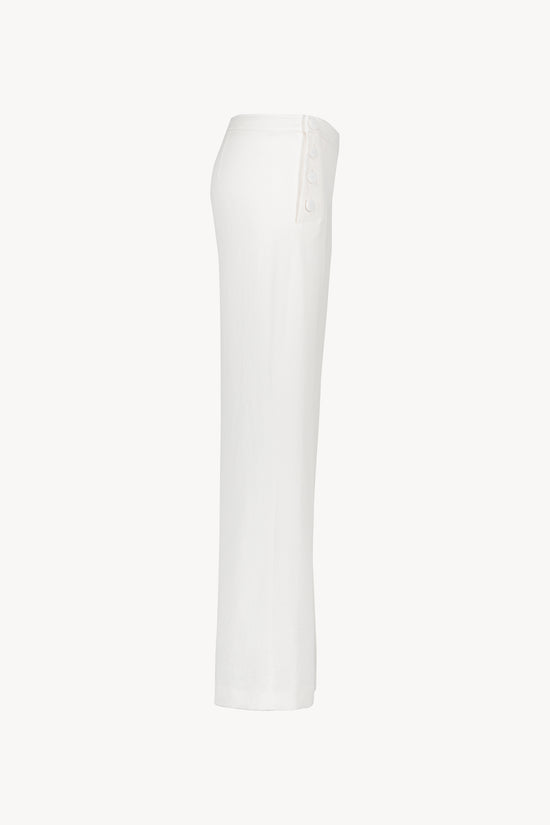Ce pantalon en lin blanc cassé avec ses poches italiennes 