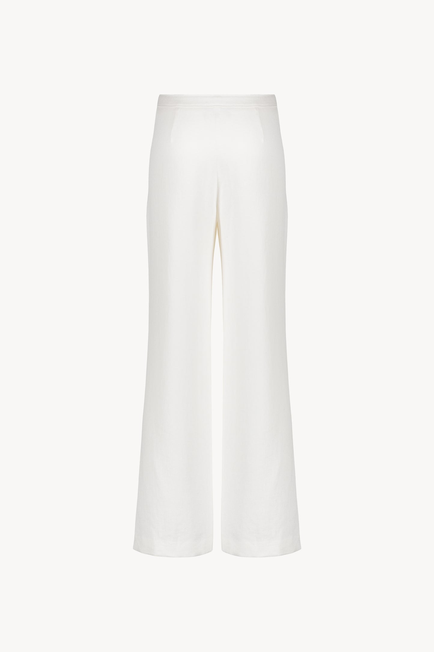 Ce pantalon en lin blanc cassé avec ses poches italiennes et sa coupe droite