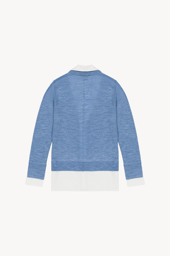 Gilet trompe-l'œil bleu en laine Merinos avec col chemise ouvert et popeline dépassante, coupe large et six boutons.