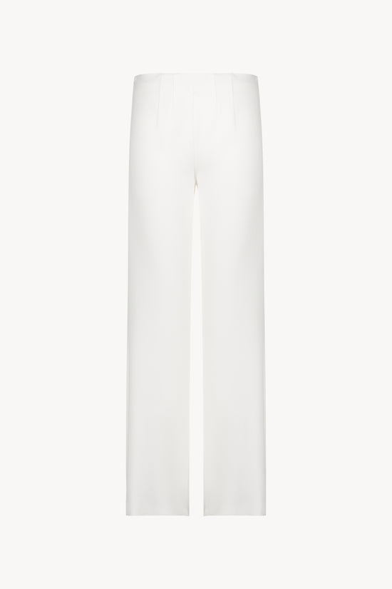Pantalon évasé blanc casse avec des plis délicats et une coupe fluide.