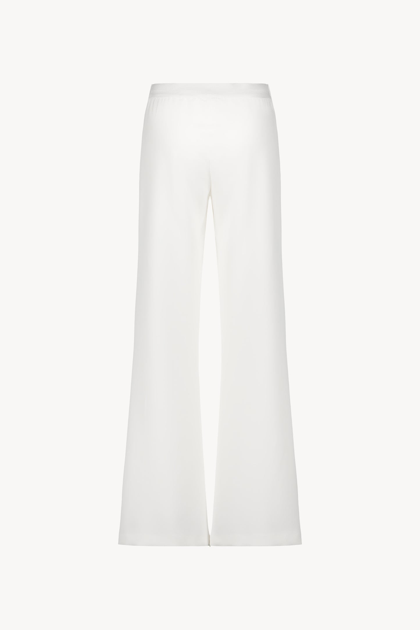 Pantalon évasé blanc casse avec des plis délicats et une coupe fluide.