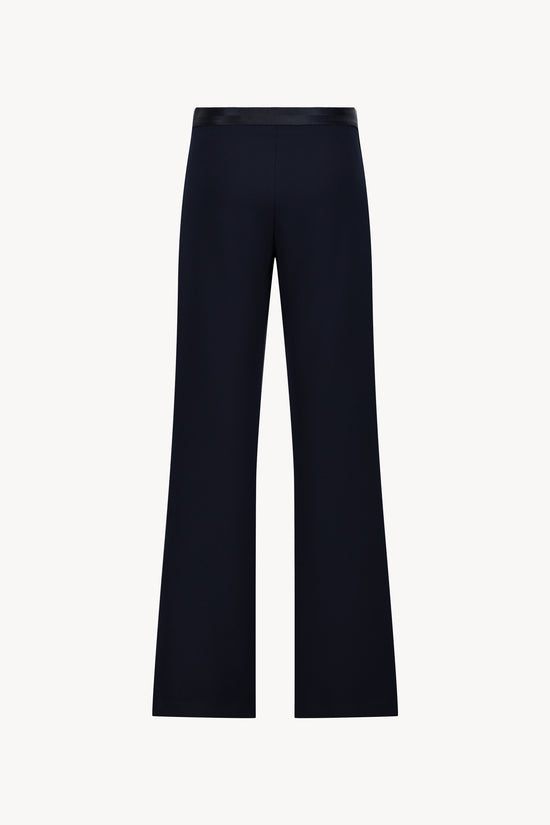 Pantalon évasé marine avec des plis délicats et une coupe fluide.