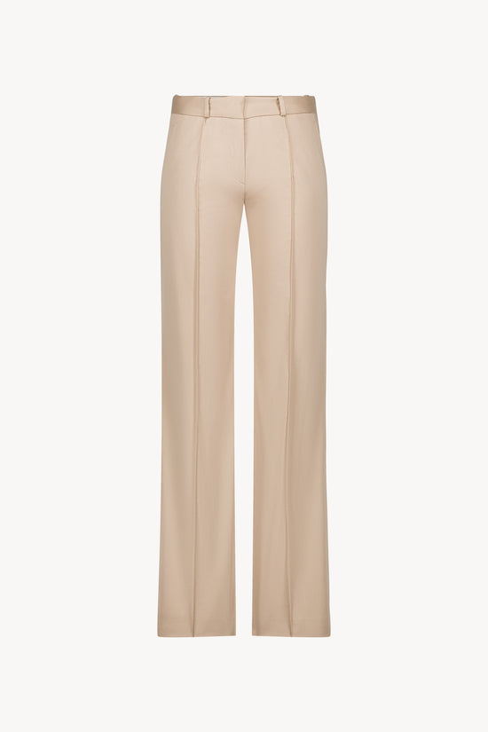 Élégant et raffiné, ce pantalon évasé en satin de coton beige allie confort et modernité .