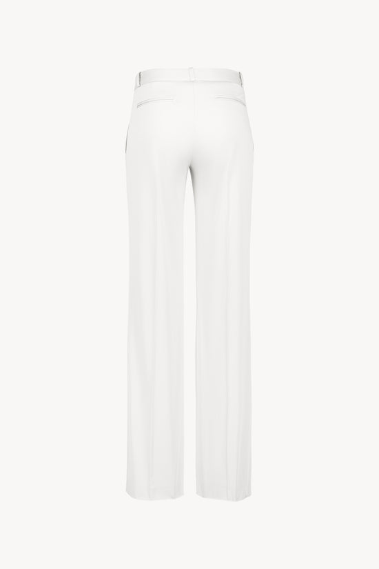 Pantalon chic en satin de coton blanc optique,  poches italiennes et coupe fluide.