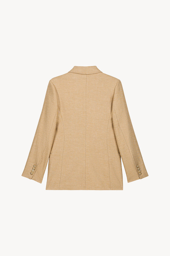 Cette veste beige en lin se distingue par sa coupe croisée, ses boutons ton sur ton et ses poches passepoilées.