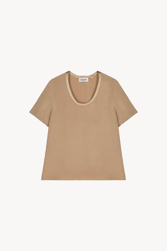 Blouse en soie lourde beige, coupe fluide et col rond élégant.