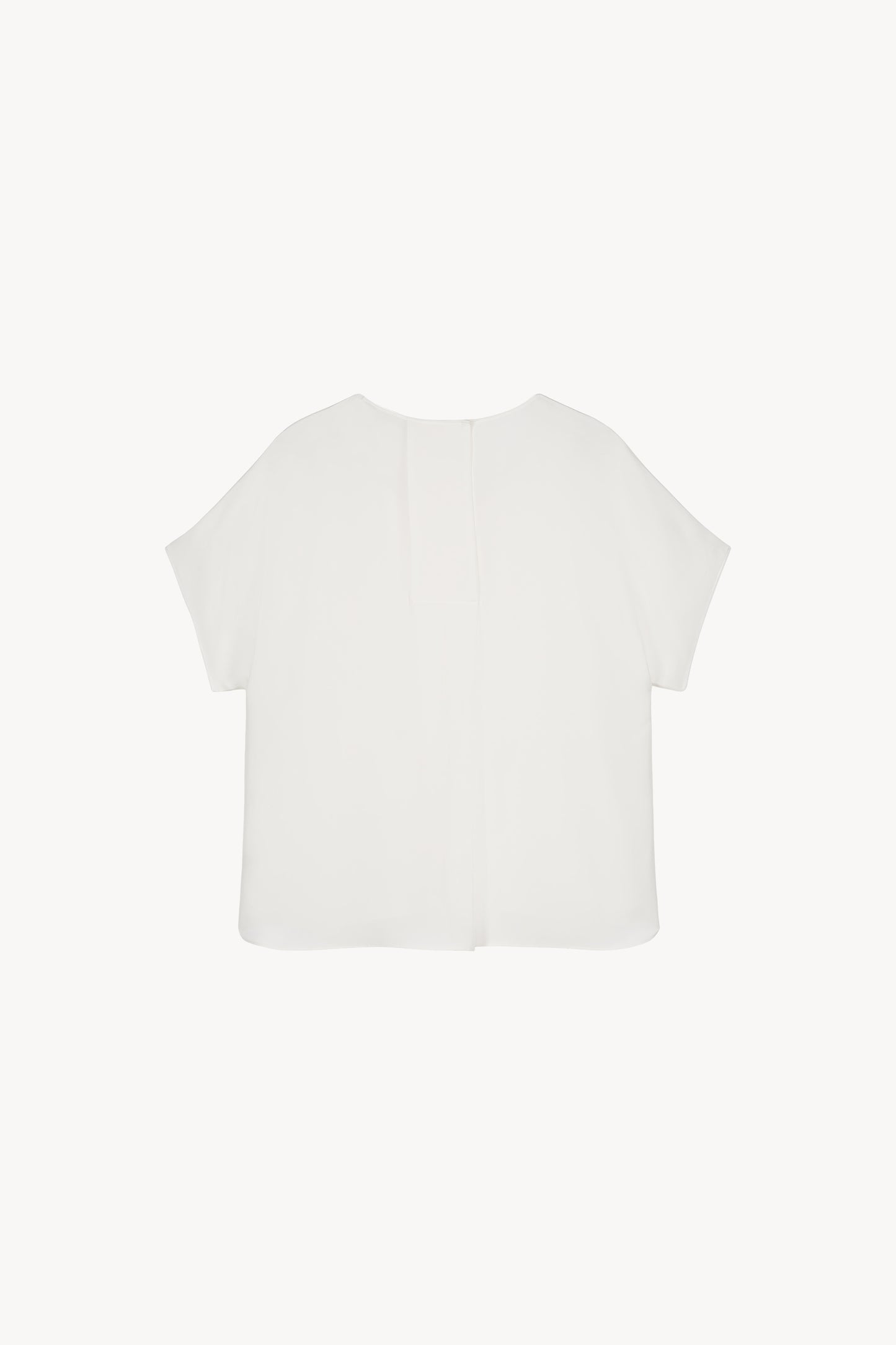 Élégante blouse marine en soie lourde, avec un design épuré et une finition parfaite.