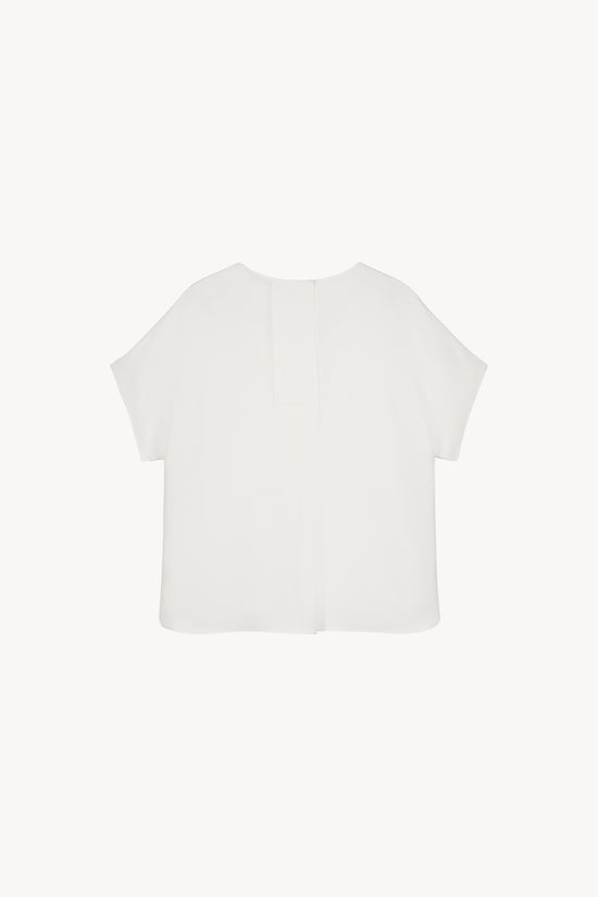 Élégante blouse marine en soie lourde, avec un design épuré et une finition parfaite.
