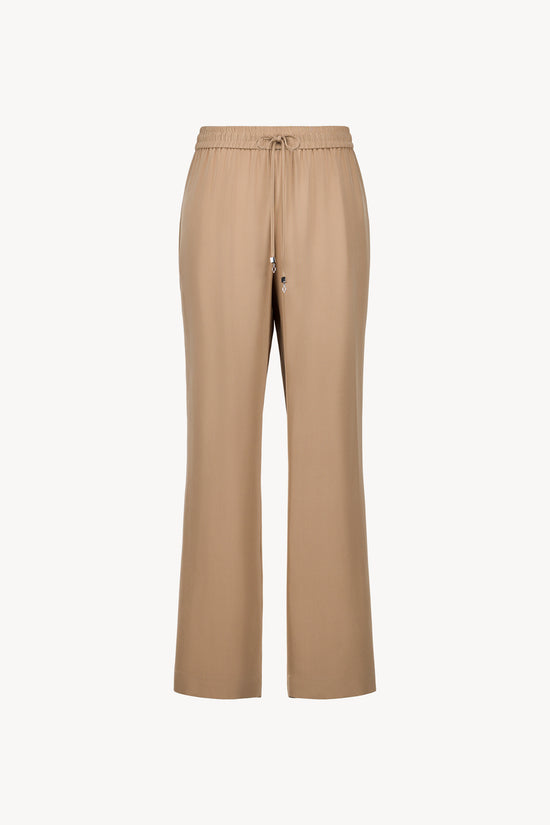 Ce pantalon en soie fluide, avec coupe droite et taille ajustable