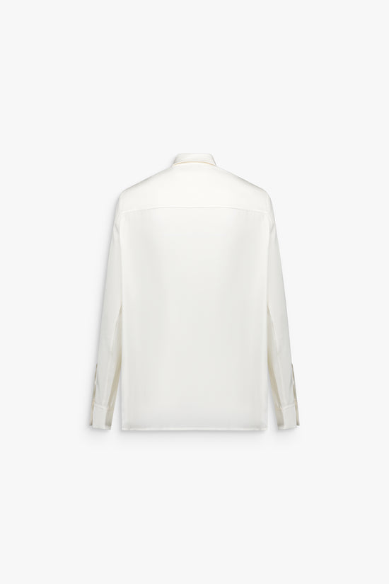 Chemise femme blanc cassé, manches longues et patte de boutonnage apparente.